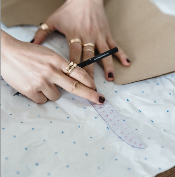 The credit is to Photo by Michael Burrows: https://www.pexels.com/photo/crop-dressmaker-with-sewing-pattern-and-ruler-on-paper-7147576/